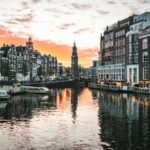 Canal houses reflected in an Amsterdam canal at sunset