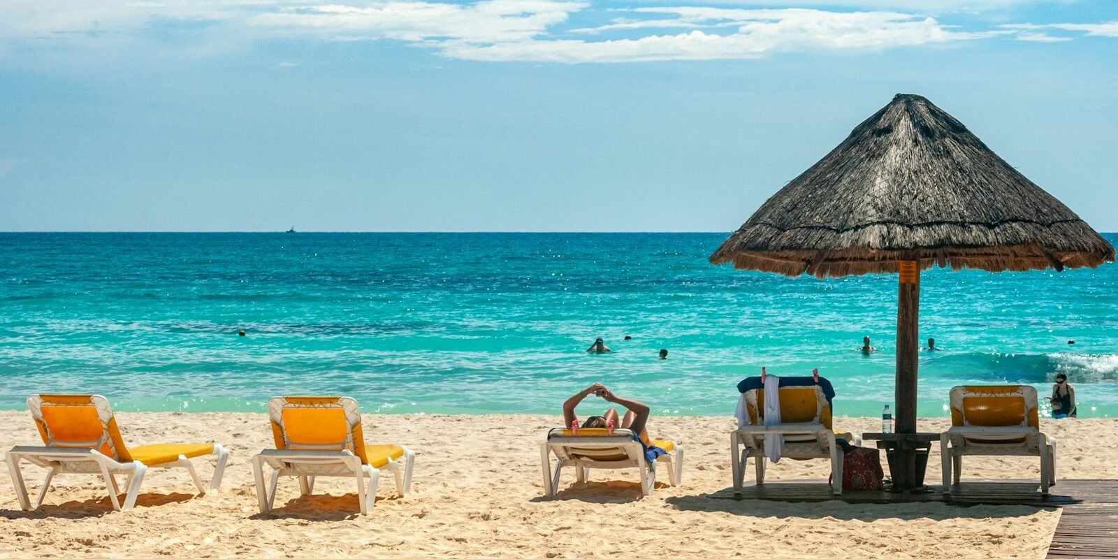 Sun loungers and a palm umbrella on a sunny Caribbean beach