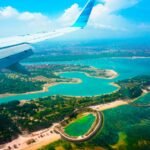 View from a plane window over a turquoise Caribbean coastline
