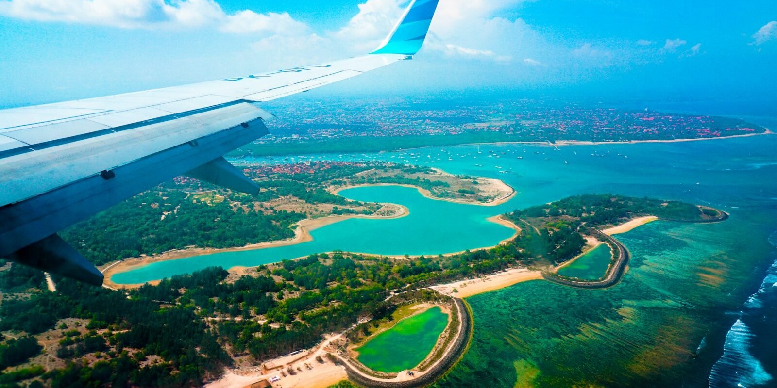 View from a plane window over a turquoise Caribbean coastline