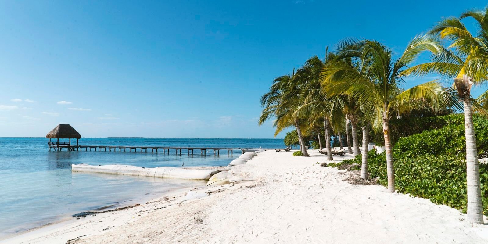 White sand, palm trees and a pier on Isla Mujeres