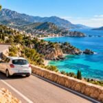 Small rental car on a coastal road above a turquoise sea