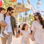Happy family with balloons on a sunny day at a theme park near Paris