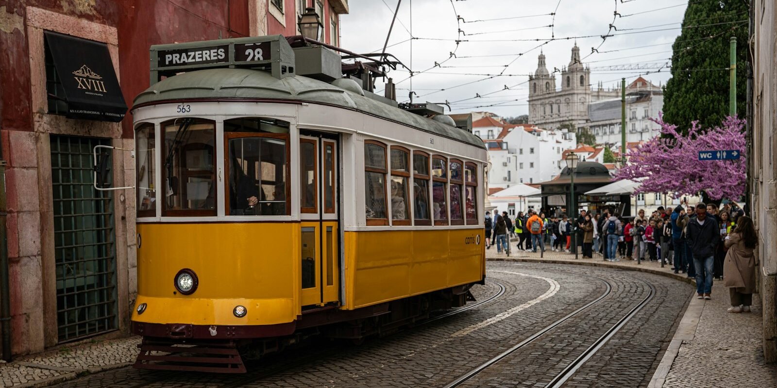 A yellow tram on a Lisbon street
