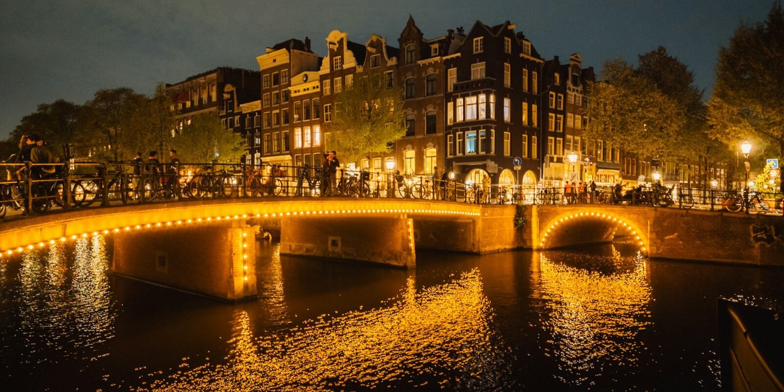 Lit bridges over an Amsterdam canal at night