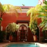 A riad courtyard with a pool and palm trees in Marrakech