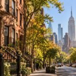 Manhattan street with brownstone houses and Midtown skyscrapers
